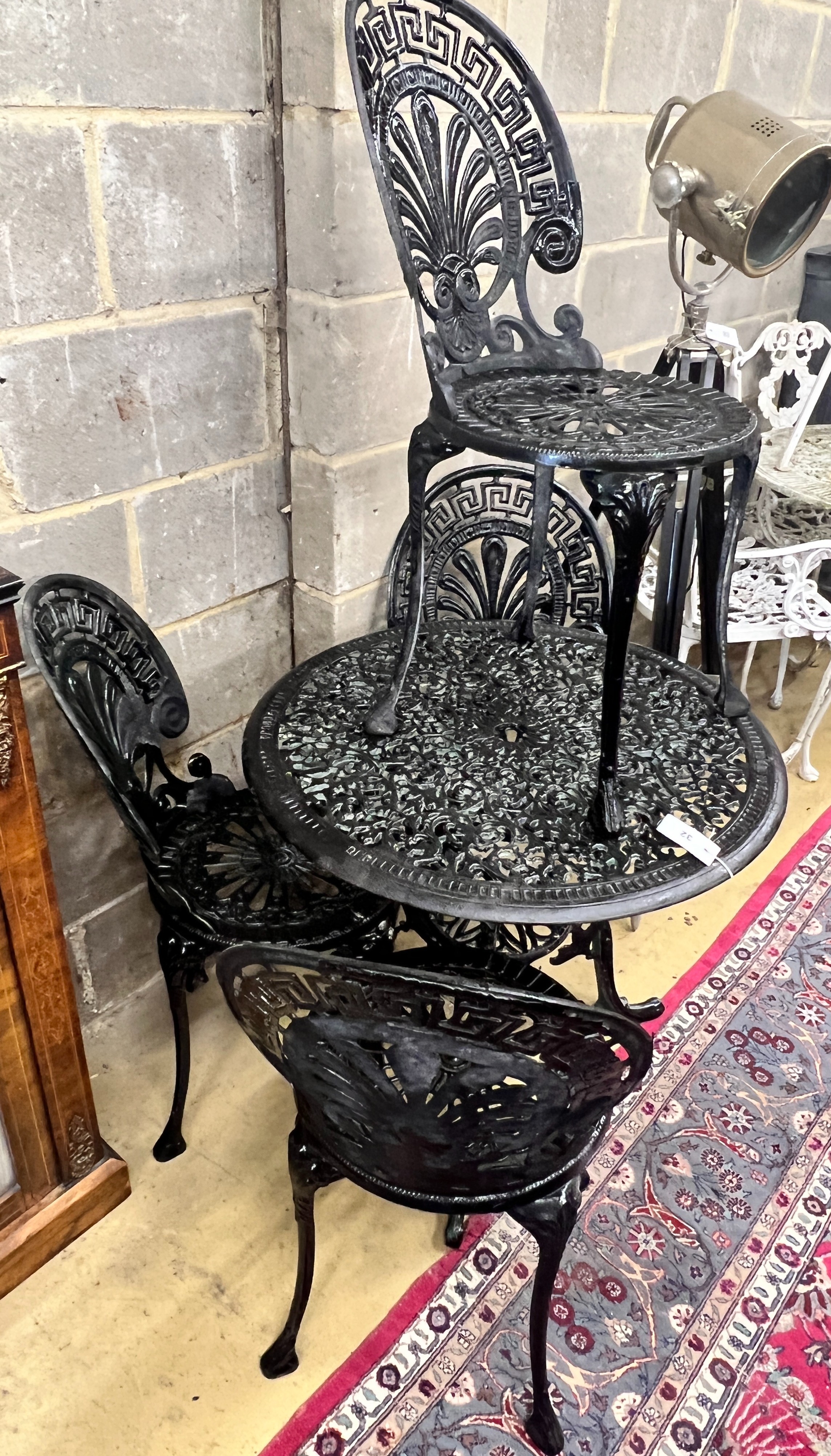 A Victorian style painted aluminium circular garden table, diameter 70cm, height 67cm and four chairs